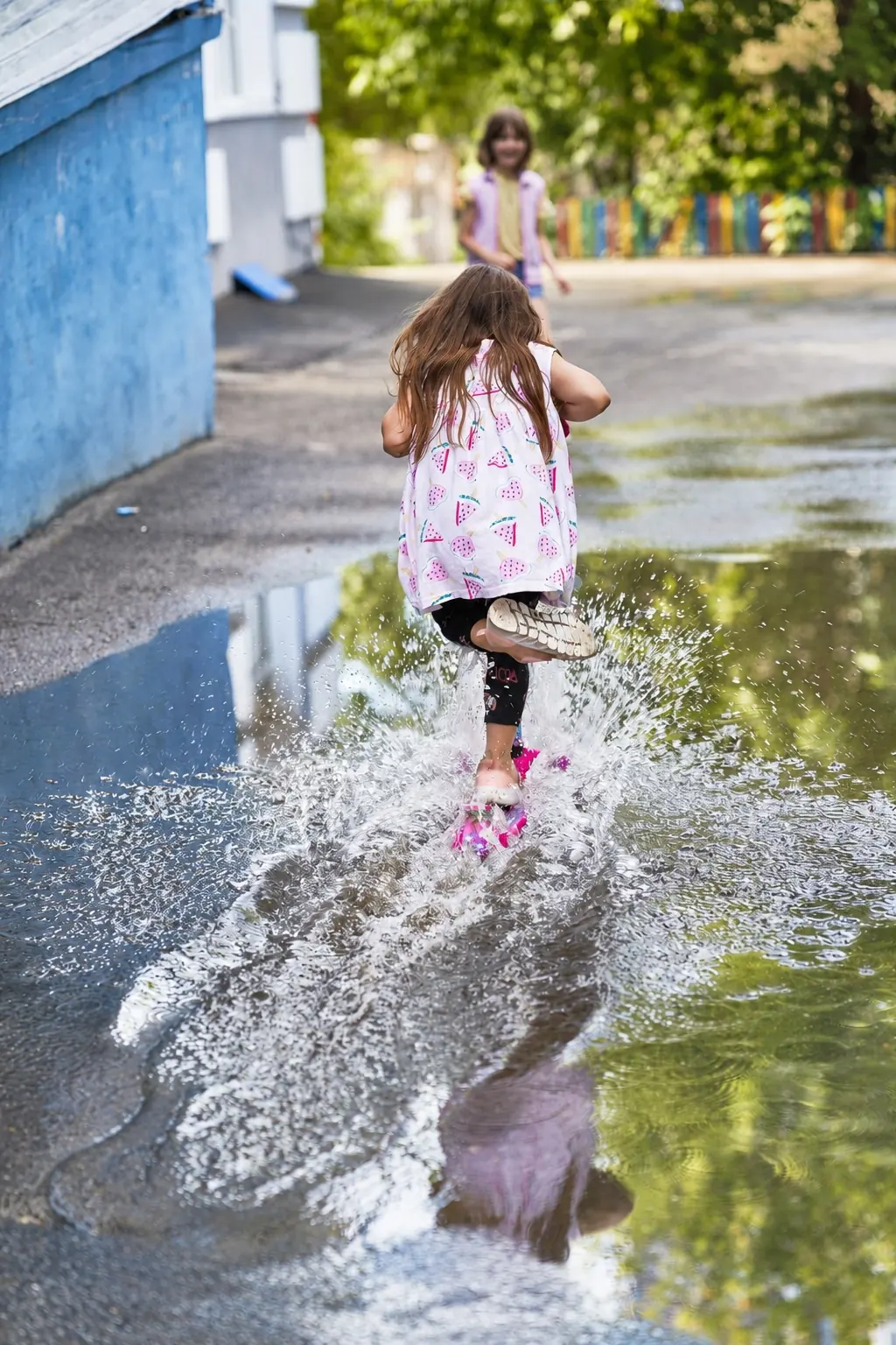 A child splashing through a puddle
